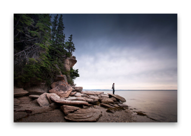 Je suis seul sur une ile face au fleuve Saint Laurent au Quebec juché sur un rocher au bord de l'eau.