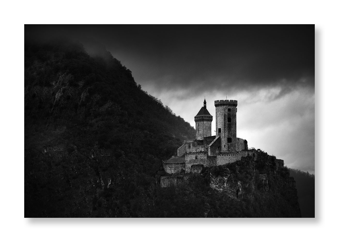 Château de Foix sur son piton rocheux avec un ciel lourd