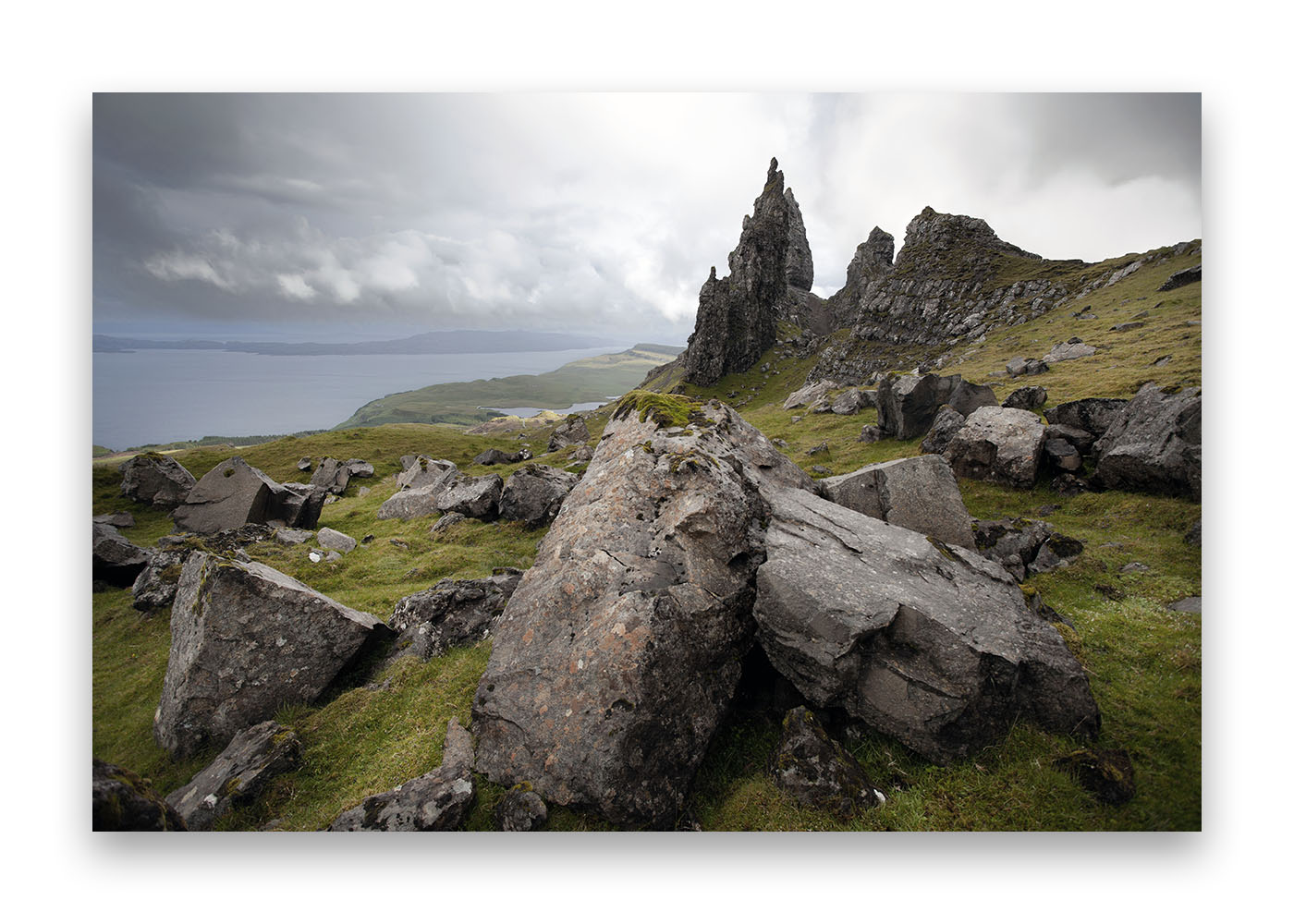 De beaux rochers en premier plan sur la lande écossaise  avec au loin un piton rocheux .